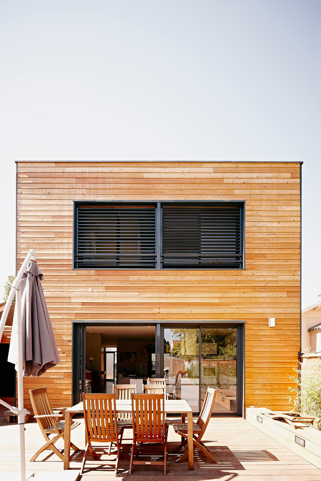 Idée de décoration pour une façade de maison marron design en bois à un étage et de taille moyenne avec un toit plat.