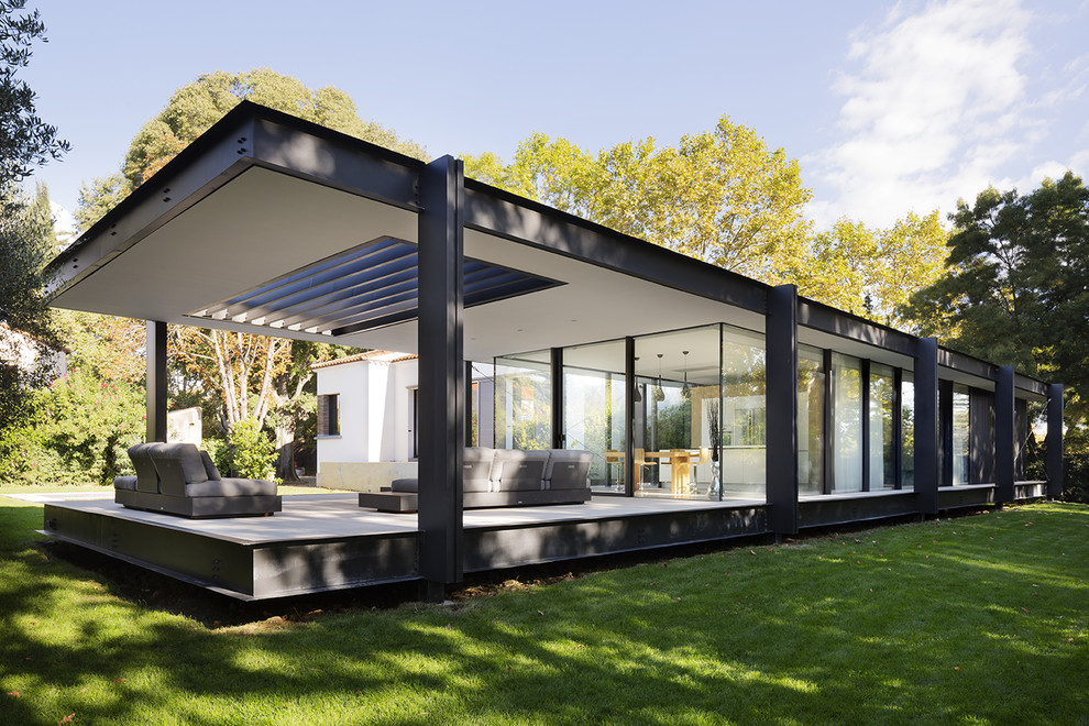 This is an example of a medium sized and black modern two floor detached house in Montpellier with metal cladding and a flat roof.