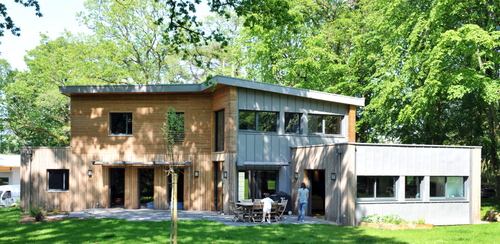 Réalisation d'une grande façade de maison marron design en bois à un étage avec un toit plat.