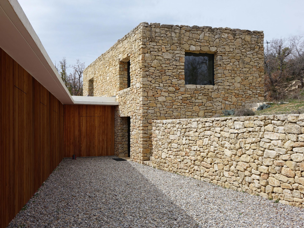 Inspiration for a large and beige rustic two floor semi-detached house in Marseille with stone cladding, a flat roof and a mixed material roof.