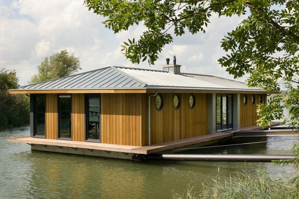 Ispirazione per la facciata di una casa eclettica a un piano di medie dimensioni con rivestimento in legno e tetto a padiglione