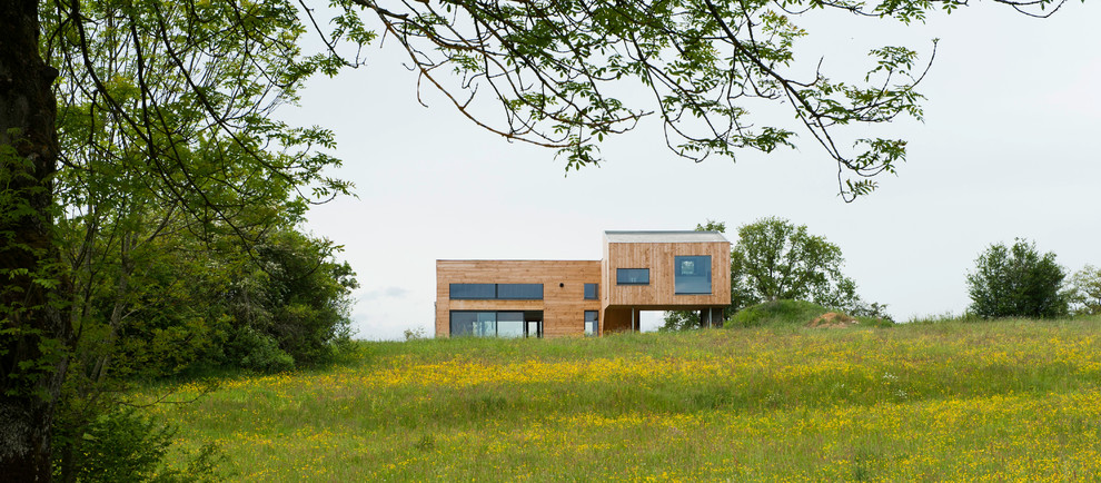 Idées déco pour une grande façade de maison marron contemporaine en bois à un étage avec un toit plat.