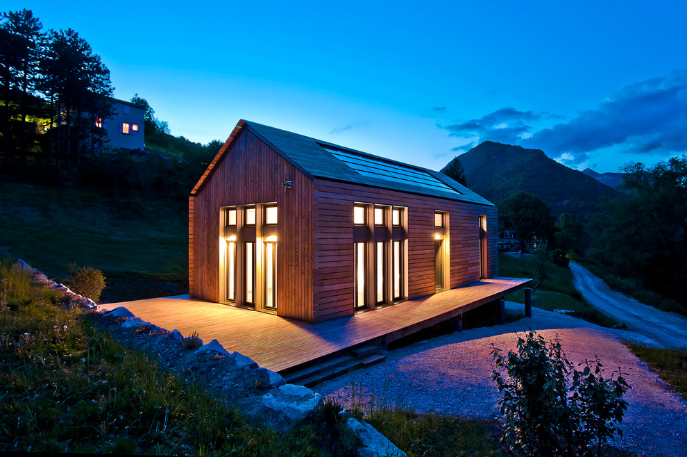 Cette photo montre une façade de maison marron tendance en bois de taille moyenne et à un étage avec un toit à deux pans.