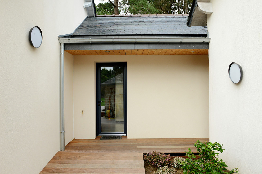 Imagen de fachada beige contemporánea de tamaño medio de una planta con revestimiento de hormigón y tejado a dos aguas
