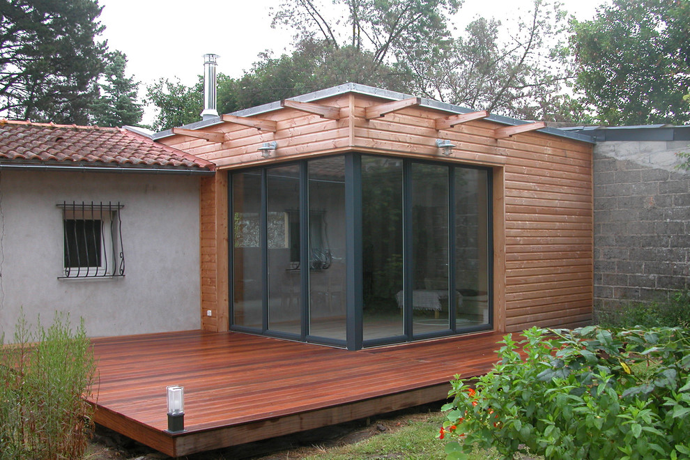 Стильный дизайн: одноэтажный, деревянный, коричневый дом среднего размера в стиле фьюжн с плоской крышей - последний тренд
