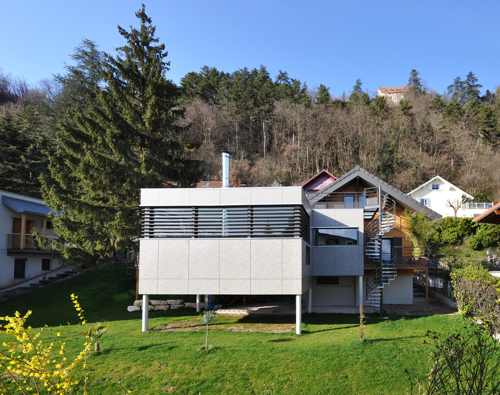 Пример оригинального дизайна: большой, двухэтажный, серый дом в современном стиле с облицовкой из бетона и плоской крышей