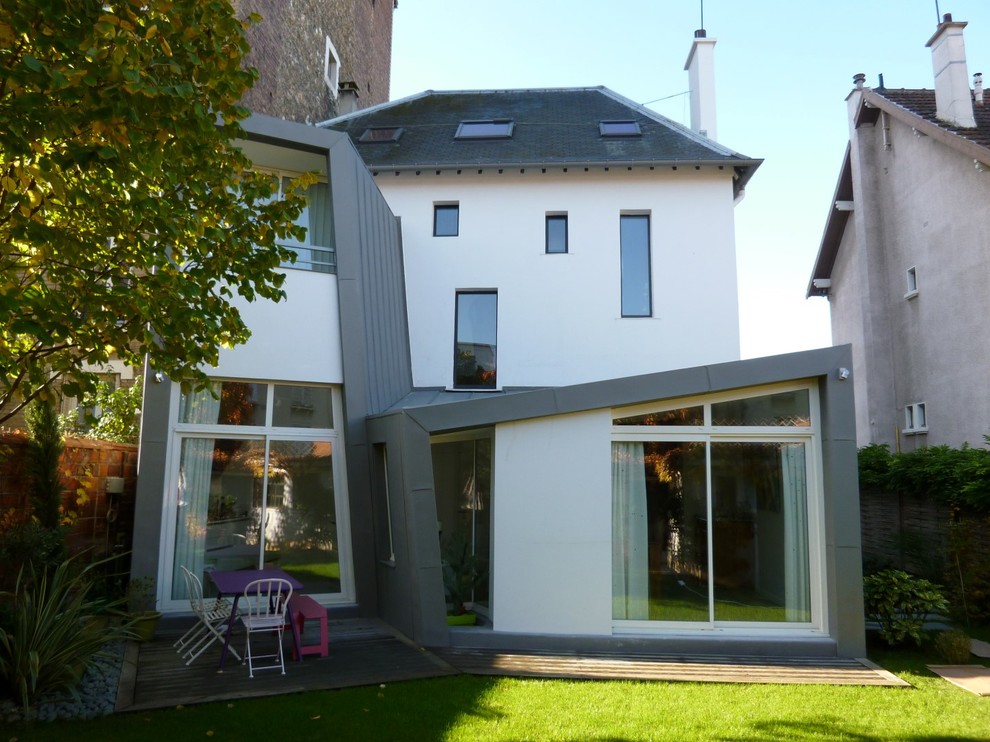 Cette image montre une façade de maison grise design à deux étages et plus.