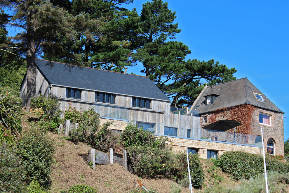 Inspiration pour une façade de maison marron marine à un étage avec un revêtement mixte, un toit à quatre pans et un toit en shingle.