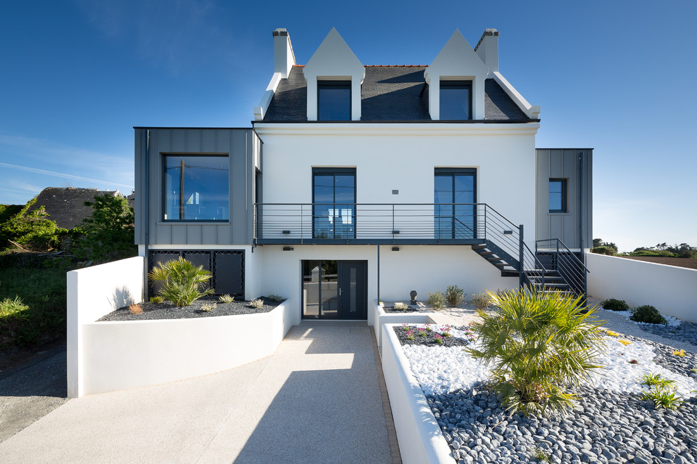 Стильный дизайн: двухэтажный, белый дом среднего размера в современном стиле с двускатной крышей и комбинированной облицовкой - последний тренд