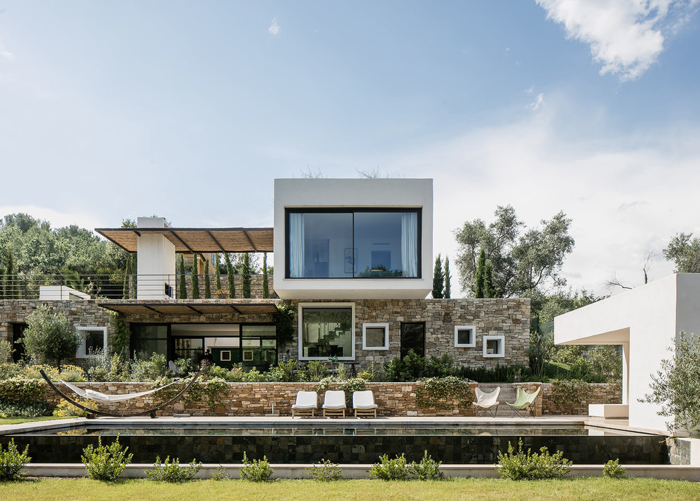 Modelo de fachada de casa multicolor contemporánea grande de dos plantas con revestimiento de estuco y tejado plano