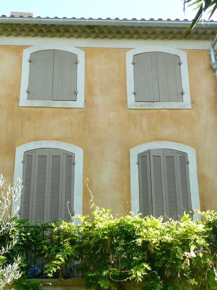 Aménagement d'une façade de maison jaune méditerranéenne de taille moyenne et à deux étages et plus.