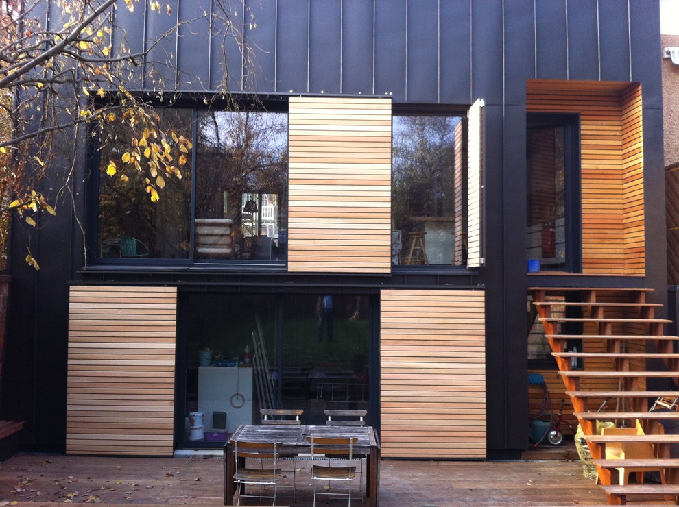Inspiration pour une façade de maison noire minimaliste en bois à deux étages et plus.