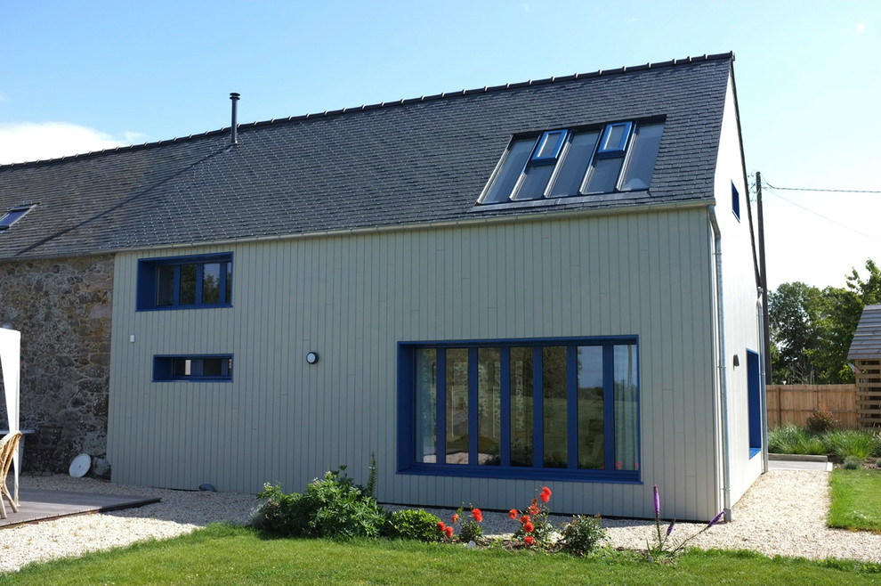 Exemple d'une grande façade de maison bleue tendance en bois à un étage avec un toit à deux pans et un toit mixte.
