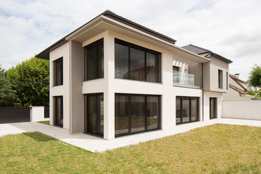 Diseño de fachada de casa pareada blanca contemporánea grande de tres plantas con revestimientos combinados, tejado a cuatro aguas y tejado de varios materiales