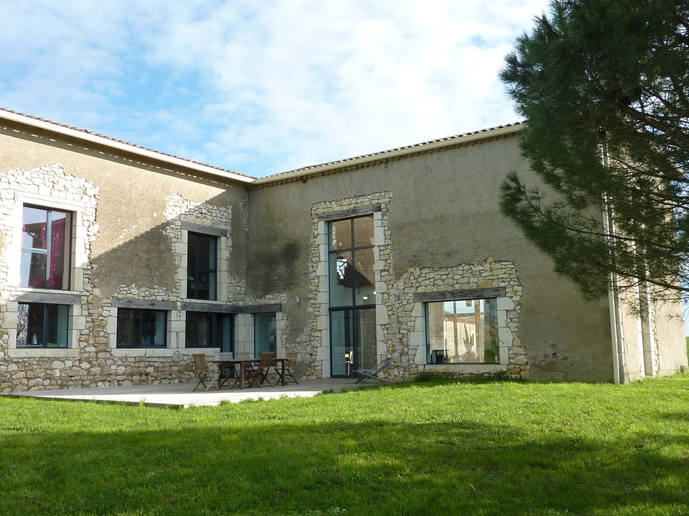 Inspiration for a beige and large country two floor detached house in Toulouse with stone cladding, a pitched roof and a tiled roof.