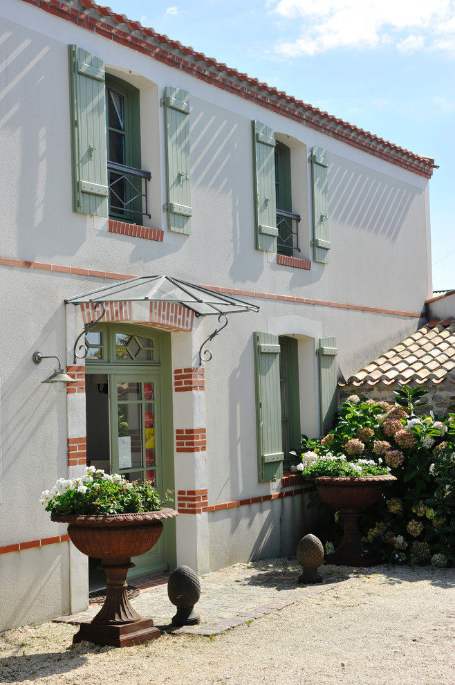 Foto de fachada blanca tradicional de tamaño medio de dos plantas con tejado a dos aguas