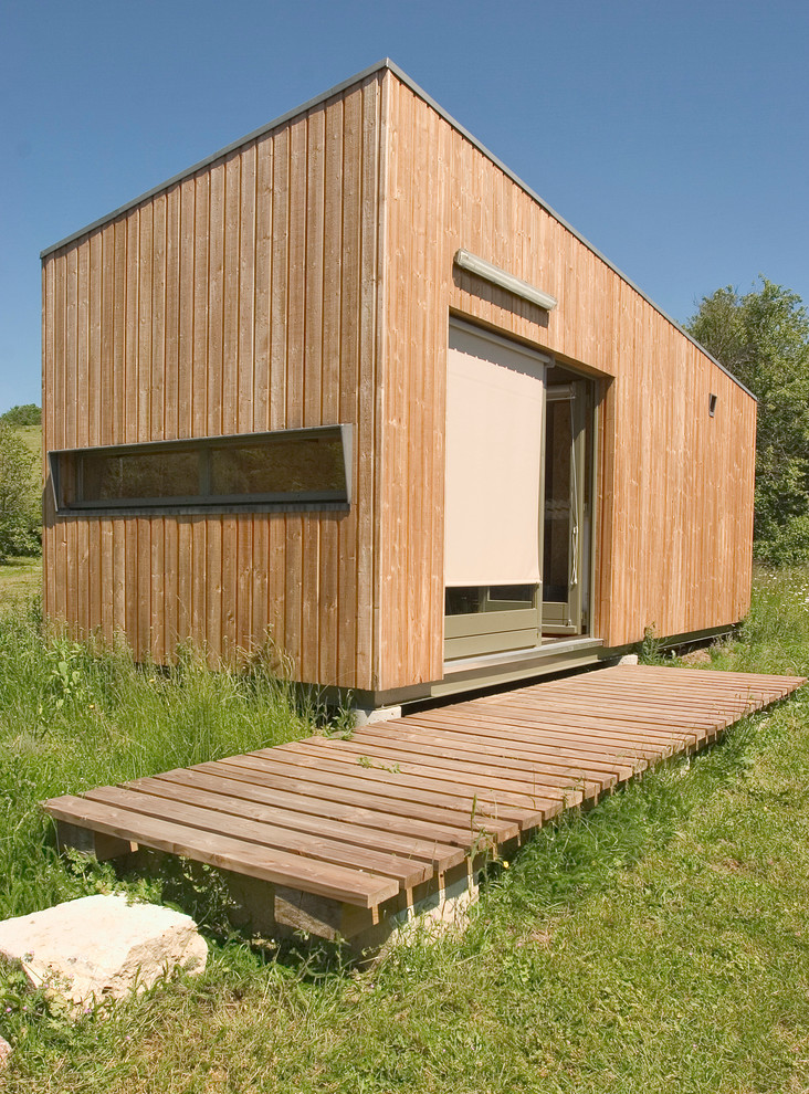 На фото: одноэтажный, деревянный, коричневый дом среднего размера в современном стиле с плоской крышей