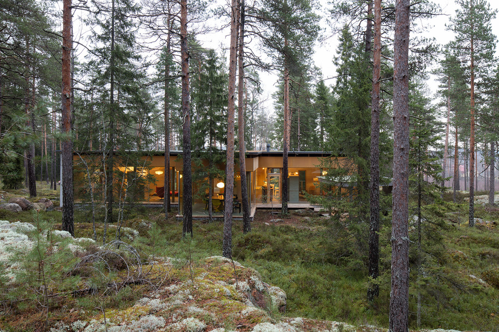 Inspiration pour une grande façade de maison grise nordique en brique de plain-pied avec un toit plat et un toit mixte.