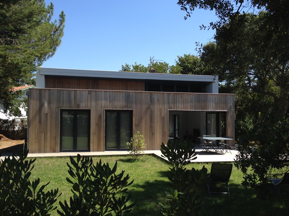Diseño de fachada marrón actual de tamaño medio de dos plantas con revestimiento de madera y tejado plano