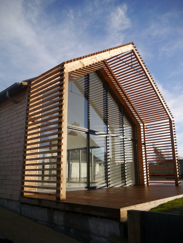 Стильный дизайн: деревянный, коричневый частный загородный дом среднего размера в современном стиле с двускатной крышей - последний тренд