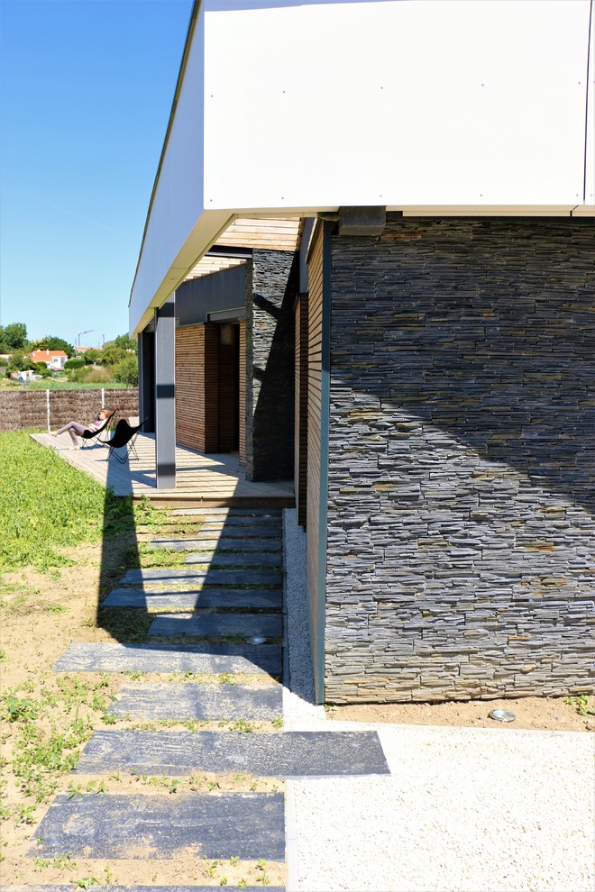 Immagine della facciata di una casa nera contemporanea a un piano di medie dimensioni con rivestimento in legno e tetto piano