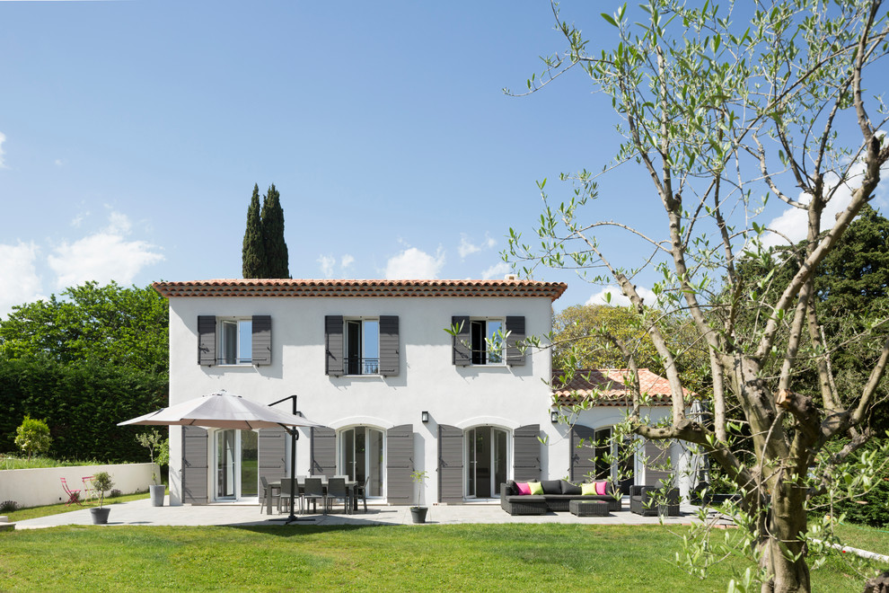 Zweistöckiges Mediterranes Einfamilienhaus mit Mix-Fassade, weißer Fassadenfarbe, Satteldach und Ziegeldach in Nizza