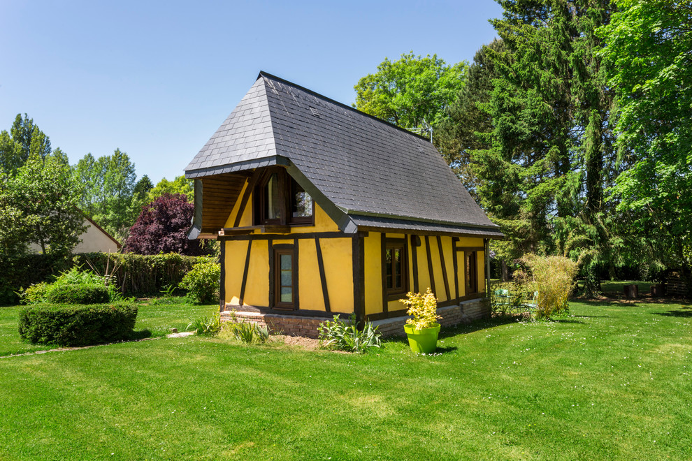 Kleines, Zweistöckiges Klassisches Haus mit Lehmfassade, gelber Fassadenfarbe und Halbwalmdach in Paris