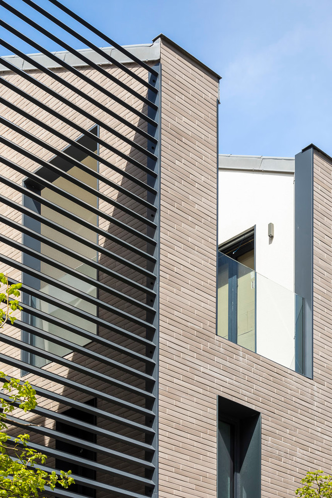 Inspiration for a large and brown contemporary brick terraced house in Paris with three floors and a flat roof.