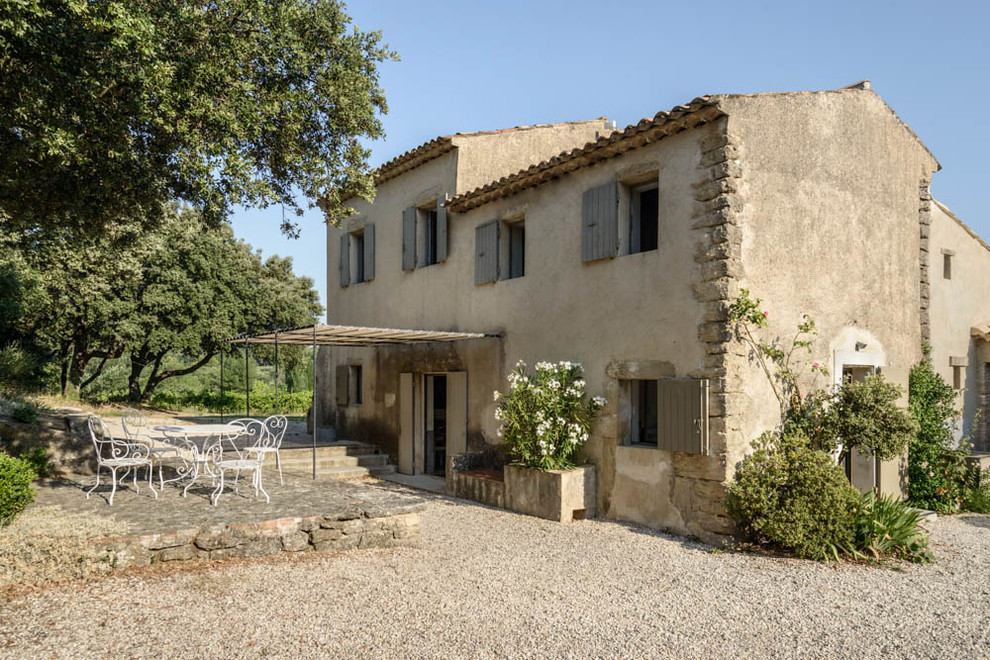 Inspiration pour une façade de maison beige méditerranéenne en pierre de taille moyenne et à un étage avec un toit en appentis.