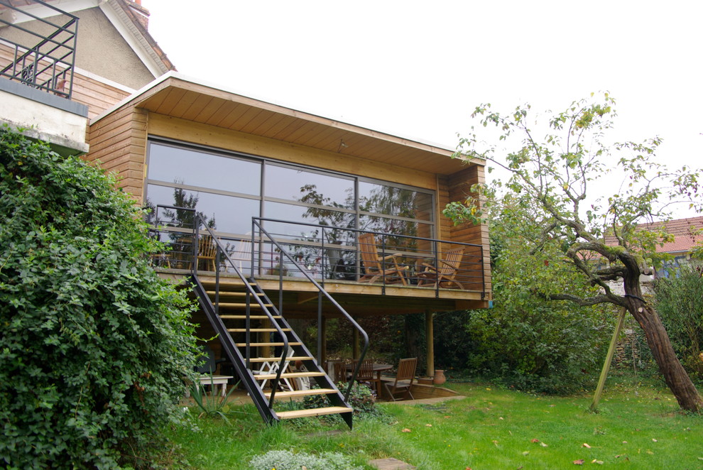 Mid-sized trendy brown split-level wood exterior home photo in Paris with a metal roof
