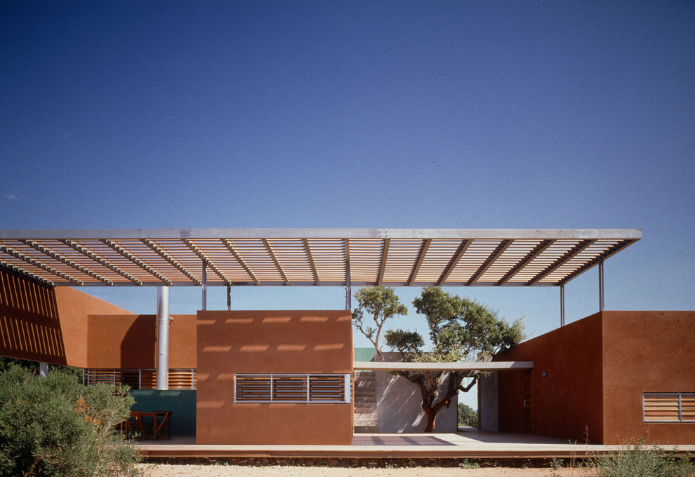 Inspiration pour une façade de maison rouge méditerranéenne de taille moyenne et de plain-pied avec un revêtement mixte et un toit plat.