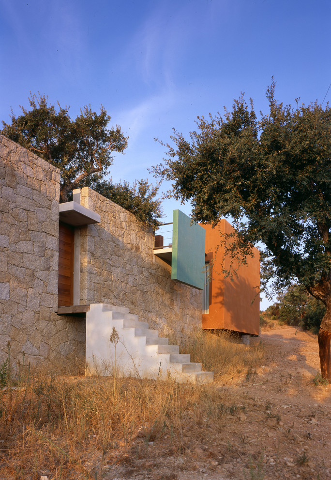 Aménagement d'une façade de maison beige méditerranéenne en pierre de taille moyenne et de plain-pied avec un toit plat.