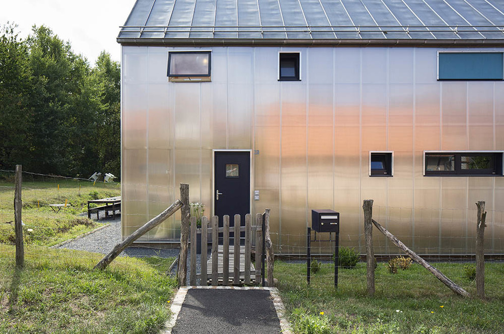 На фото: двухэтажный, стеклянный, серый дом в стиле кантри с двускатной крышей с