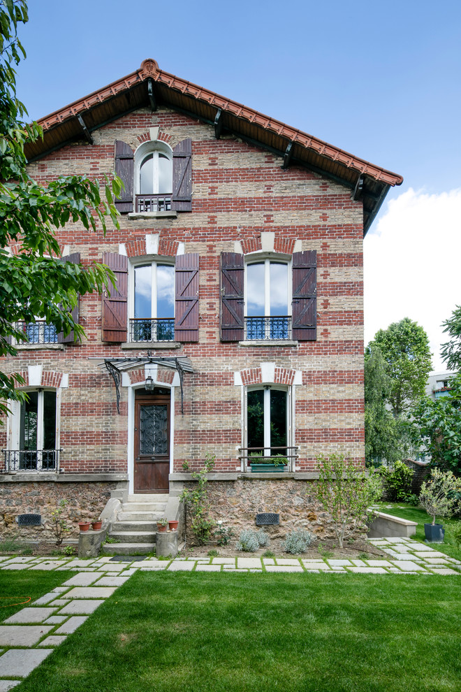 This is an example of a medium sized and red contemporary brick terraced house in Paris with three floors.