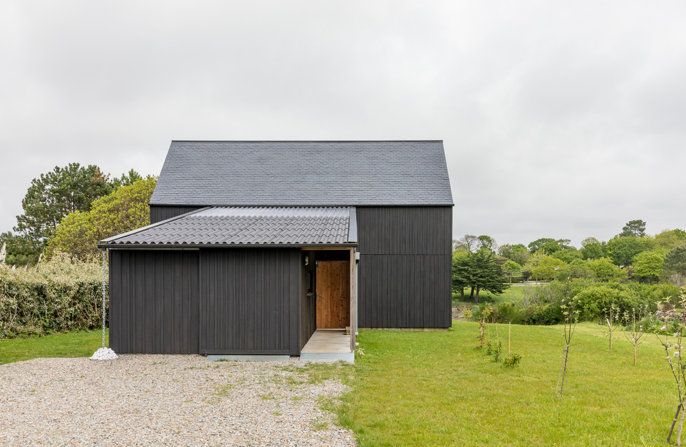 Idée de décoration pour une façade de maison noire urbaine en bois de taille moyenne et à un étage avec un toit à deux pans.