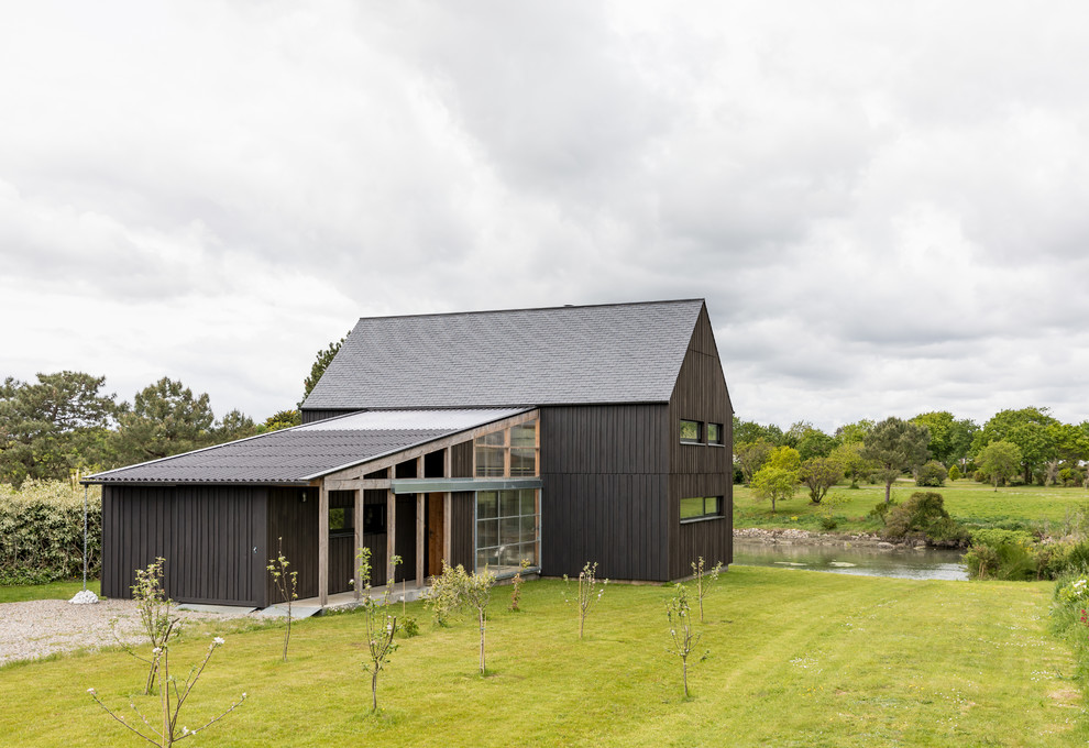 Идея дизайна: двухэтажный, деревянный, черный частный загородный дом среднего размера в стиле кантри с двускатной крышей