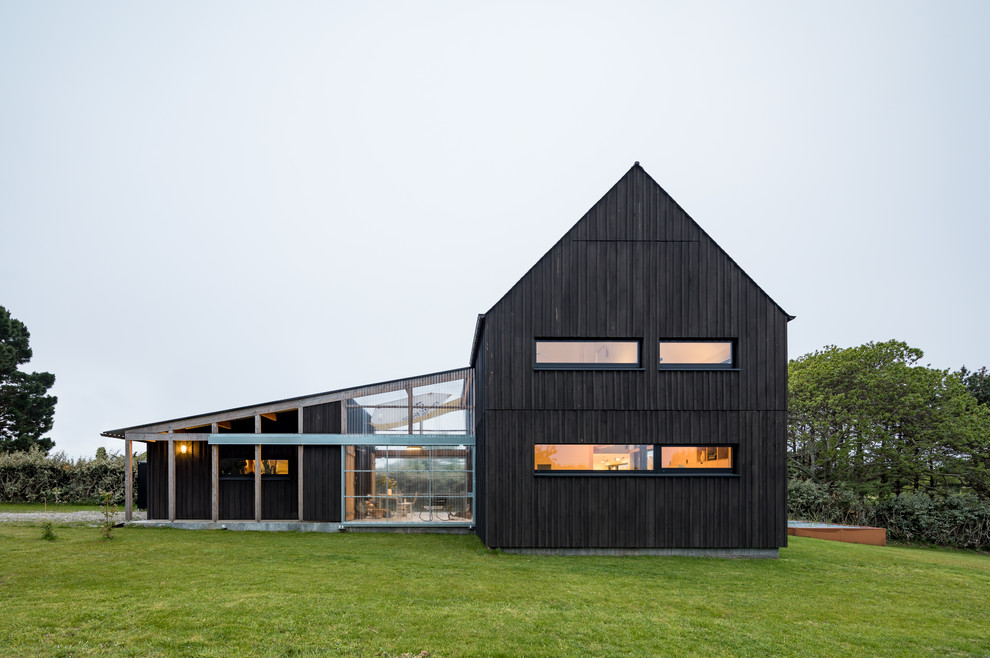 Cette photo montre une façade de maison noire industrielle de taille moyenne et à un étage avec un toit à deux pans.