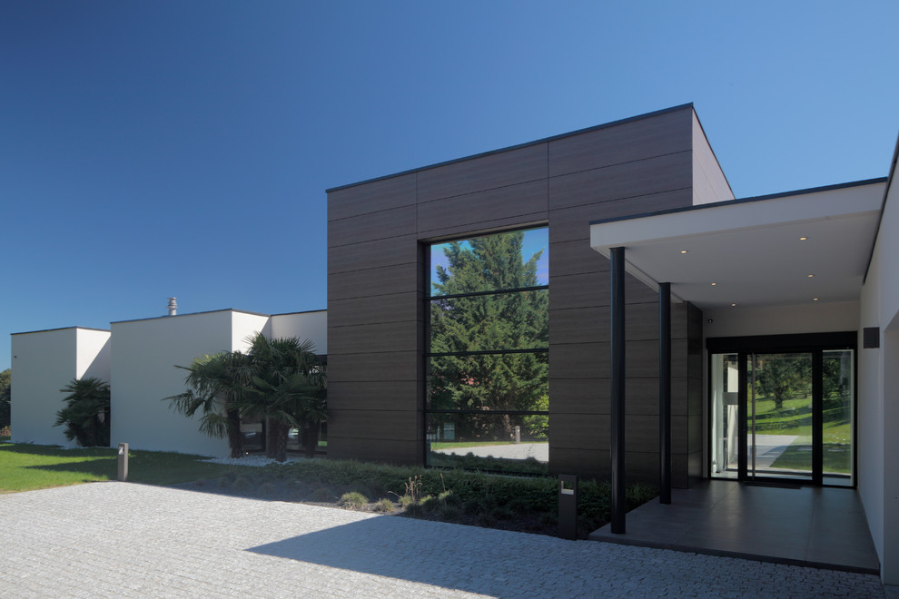 Idée de décoration pour une grande façade de maison design à un étage avec un toit plat.