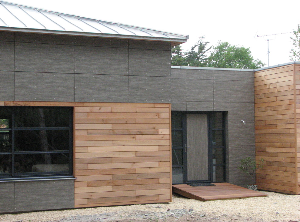 Cette photo montre une grande façade de maison marron exotique en bois de plain-pied avec un toit à quatre pans et un toit en métal.