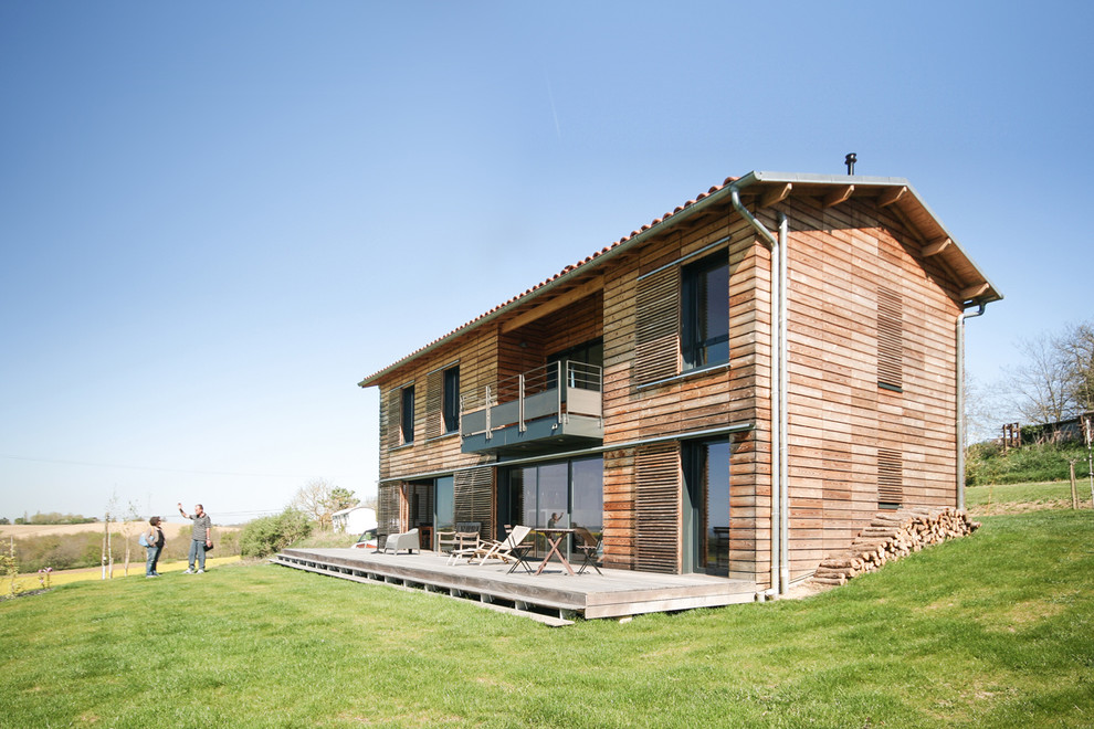 Réalisation d'une grande façade de maison marron design en bois à un étage avec un toit à deux pans.