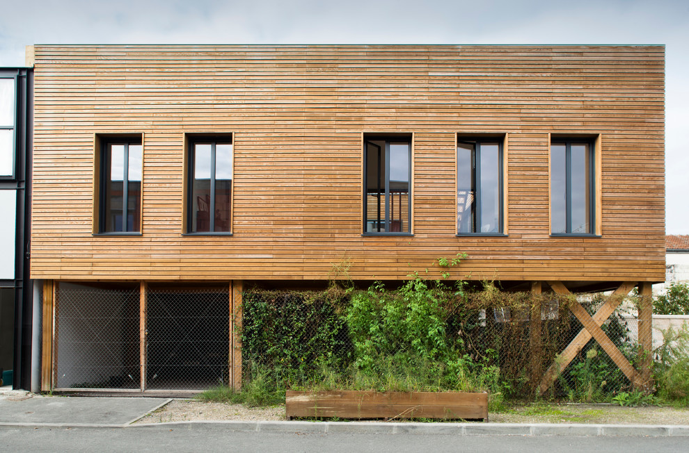 Réalisation d'une façade de maison design en bois à un étage et de taille moyenne avec un toit plat.