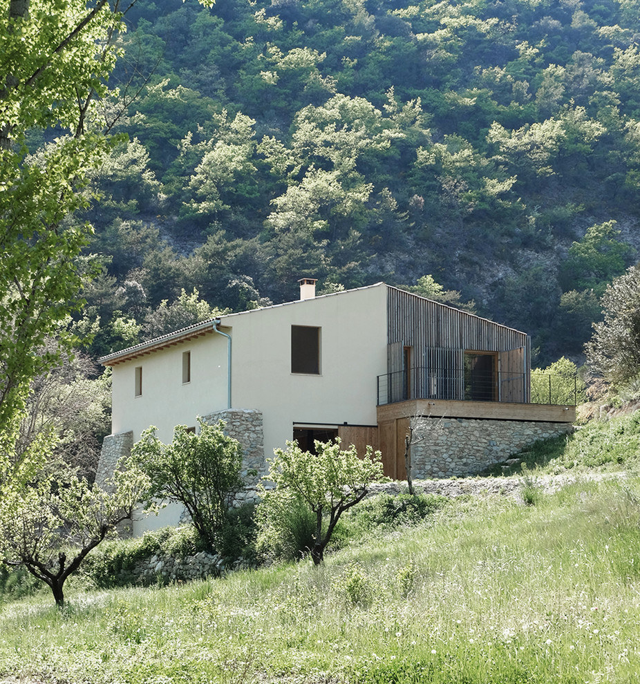 Esempio della villa grande marrone scandinava a due piani con rivestimenti misti, tetto a capanna e copertura in tegole