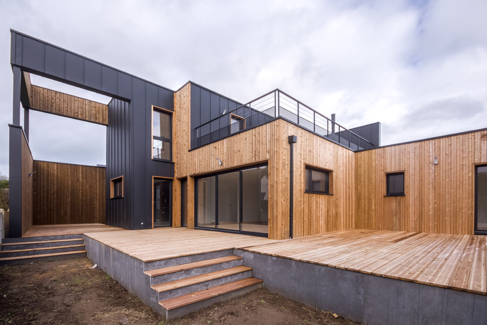 Идея дизайна: двухэтажный, черный, большой частный загородный дом в морском стиле с облицовкой из металла, плоской крышей и крышей из смешанных материалов