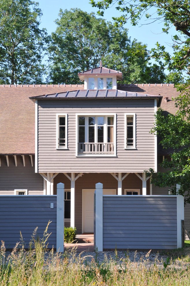 Réalisation d'une très grande façade de maison grise craftsman en bois à un étage avec un toit à deux pans et un toit en tuile.