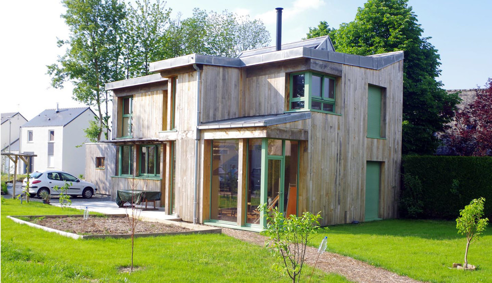 Cette image montre une façade de maison marron design en bois à un étage avec un toit en métal.