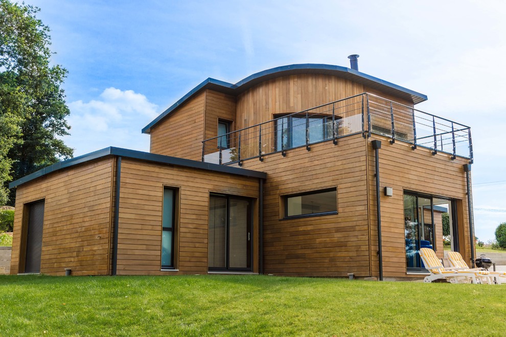 Cette photo montre une grande façade de maison marron moderne en bois à un étage.
