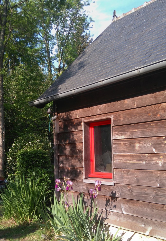 Réalisation d'une façade de maison multicolore champêtre en bois de taille moyenne et à un étage avec un toit à deux pans et un toit mixte.