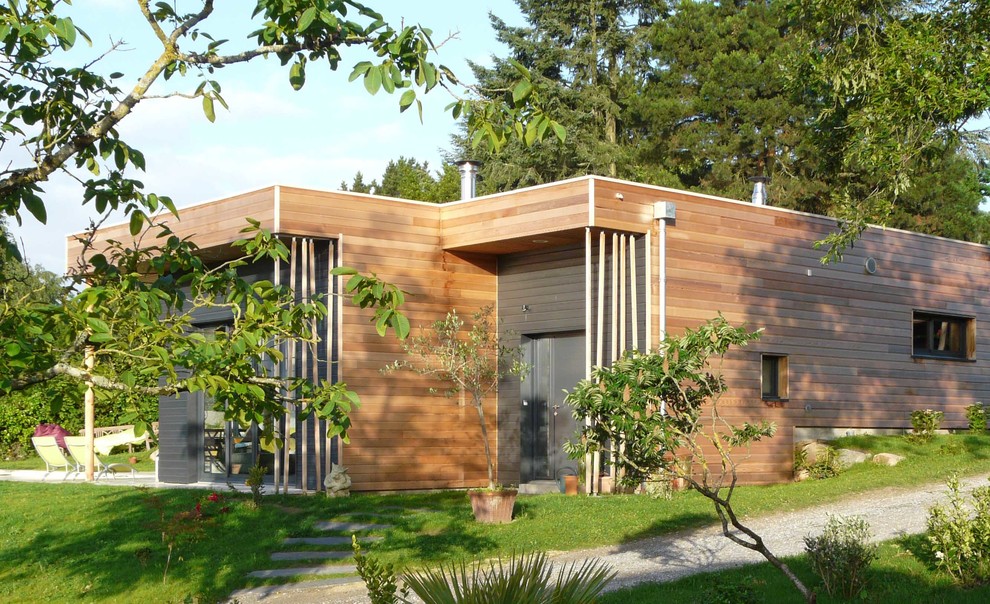 Exemple d'une façade de maison tendance en bois de taille moyenne et de plain-pied avec un toit plat.