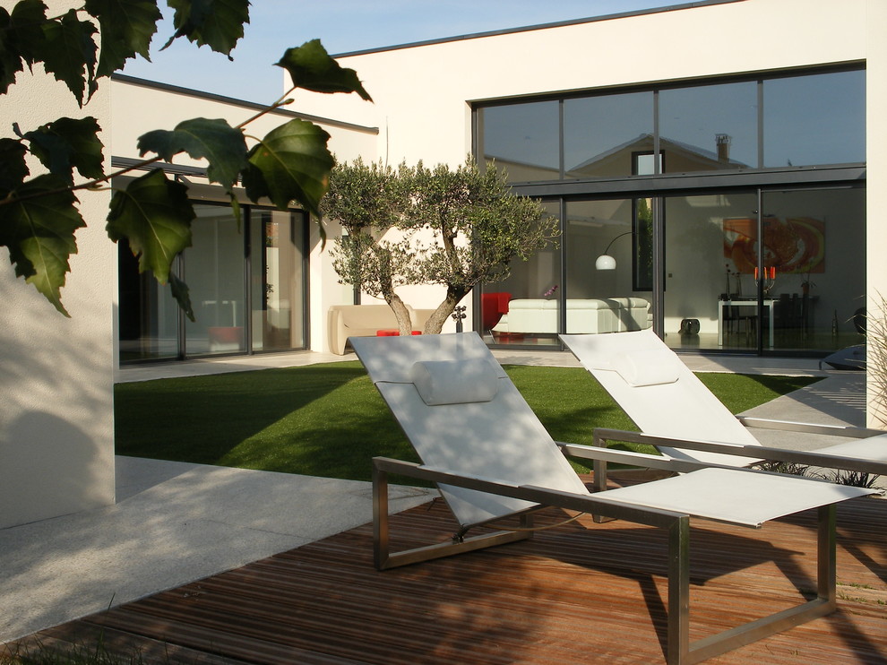 Diseño de fachada beige minimalista de una planta con tejado plano