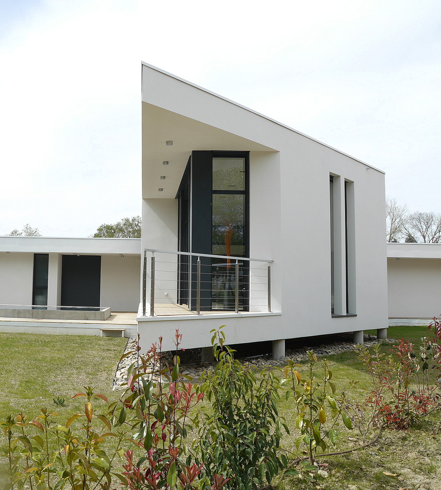 Imagen de fachada blanca actual de tamaño medio de una planta con tejado plano